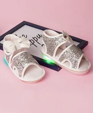 Chiu Zari Shimmer Embellished Musical LED Bow Detailed Sandals - White