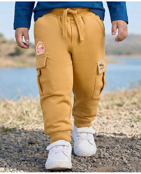 Babyhug French Terry Knit Full Length Lounge Pant With Badge Detailing & Cargo Pockets - Cream