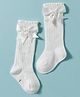 Cute Walk by Babyhug Non Terry Knit Calf Length Solid Party Socks with Bow Applique & Cable Knit Design - White